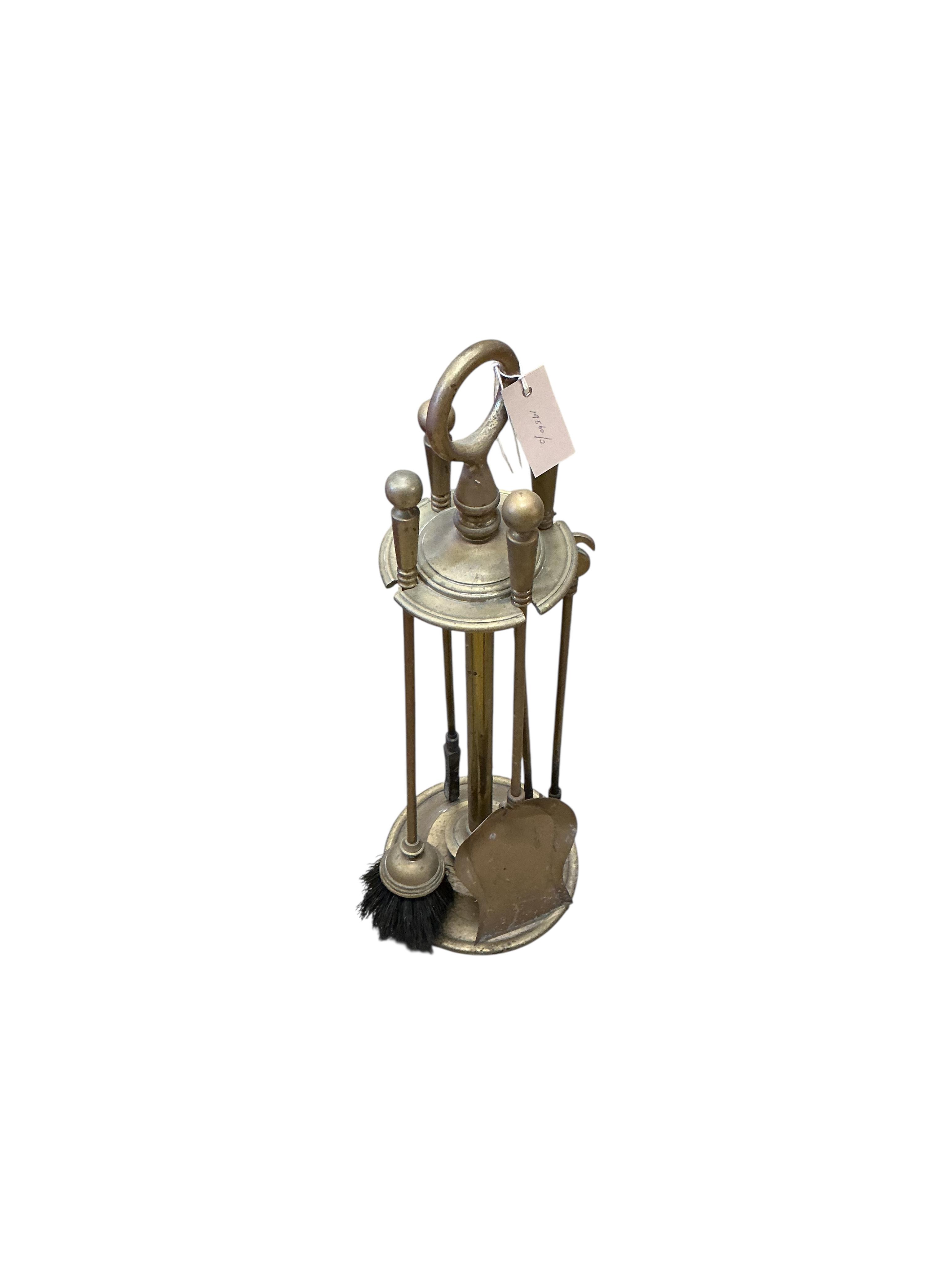 A brass four piece fire implement set, height 65cm